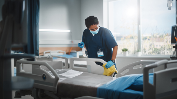 hospital cleaner wiping down beds