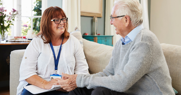 woman talking to client at home on sofa smiling comfortingly